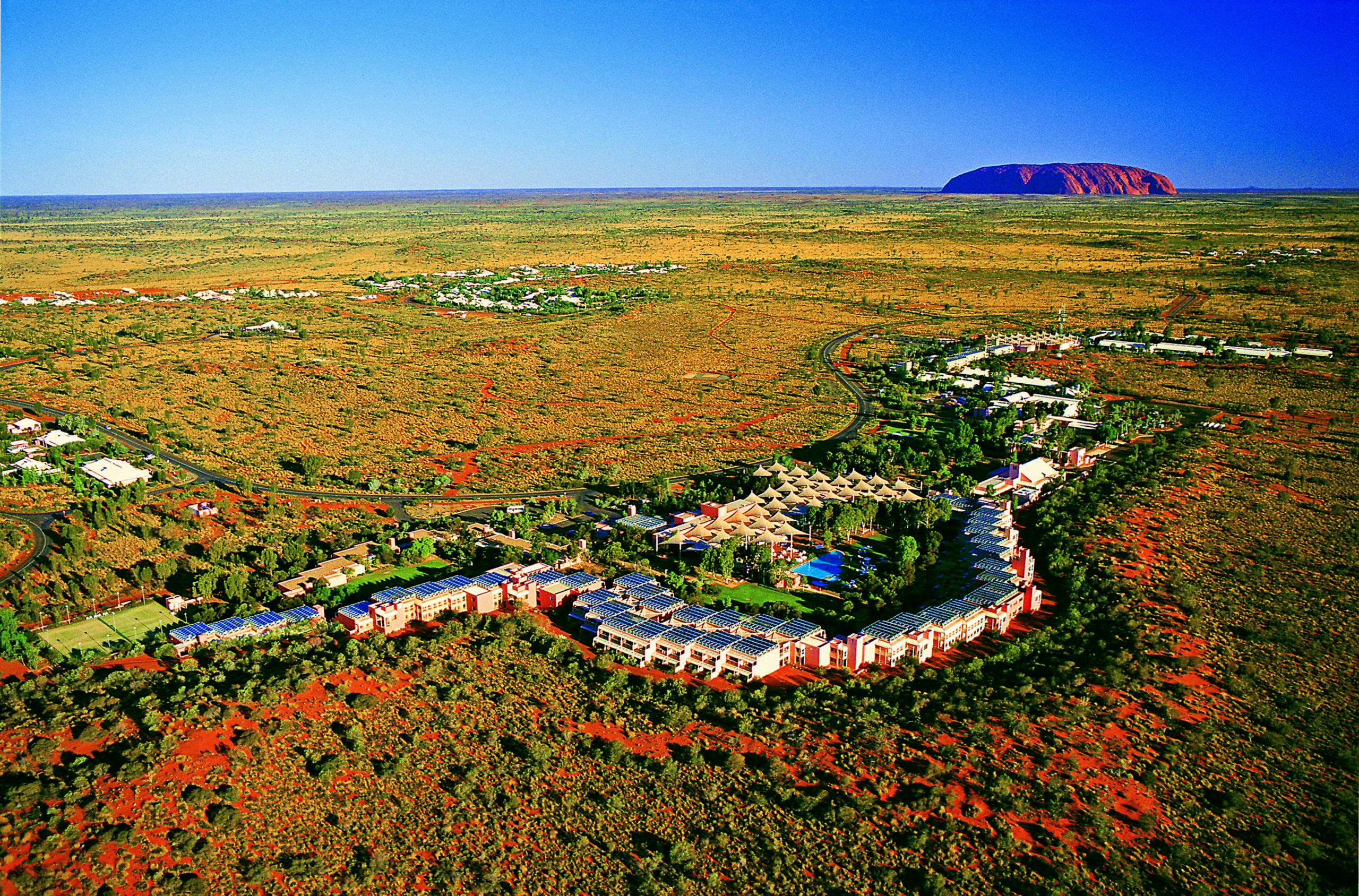 Yulara - aerial of Ayers Rock Resort with Uluru in background -